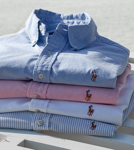 Stack of folded button-downs in light shades of blue, white & pink